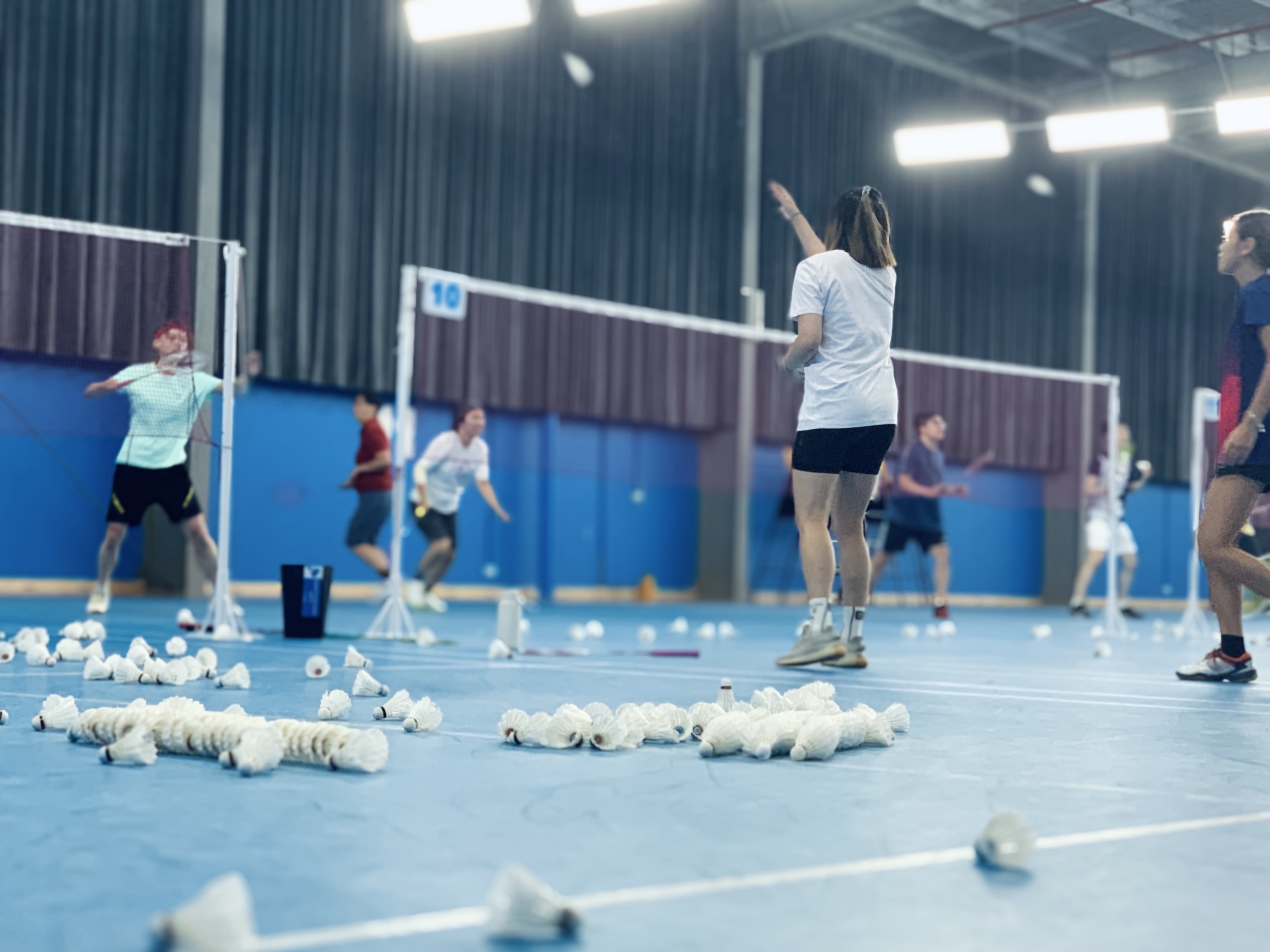 Badminton training session with players practicing on court